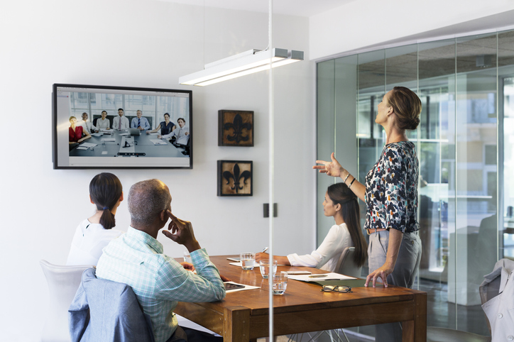 Business people video conferencing in board room
